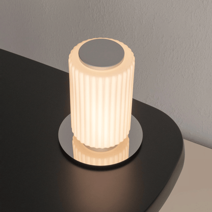 Decorative cylindrical light on a dark surface with a neutral background