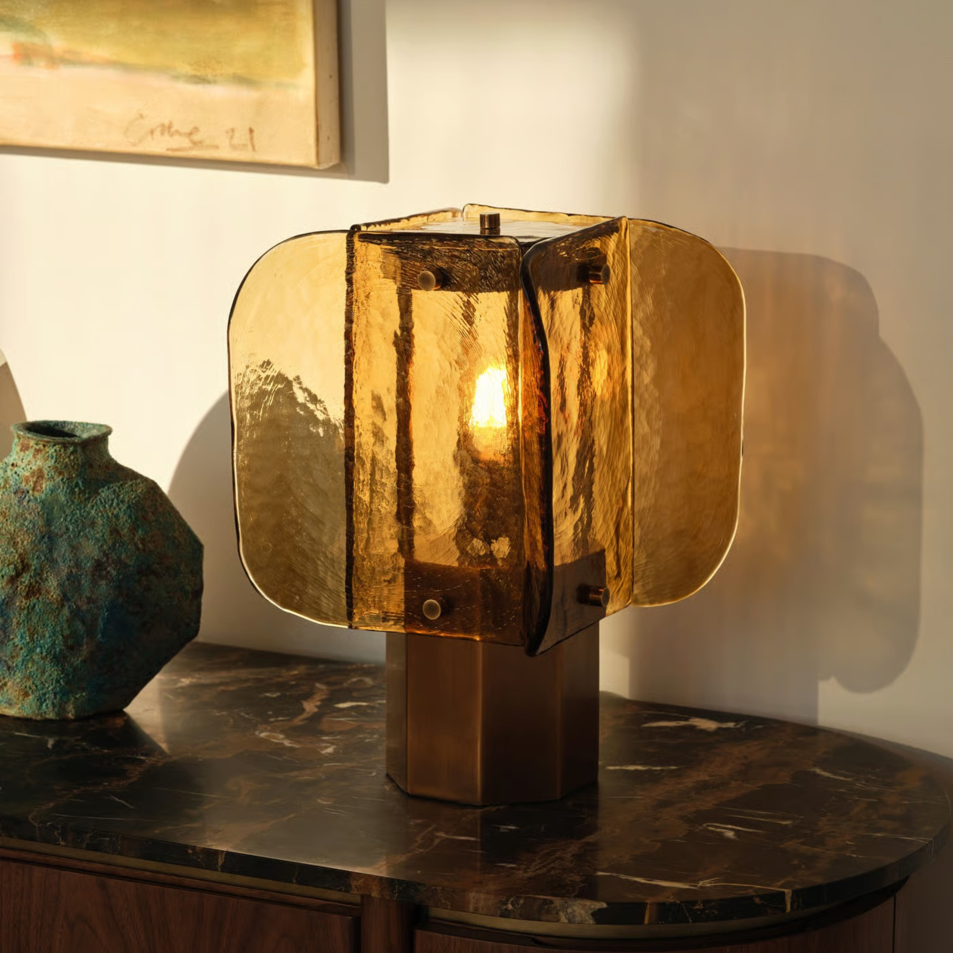 Amber glass table lamp on a marble surface emitting warm golden light, creating a cozy vintage glow