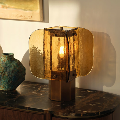 Amber glass table lamp on a marble surface emitting warm golden light, creating a cozy vintage glow