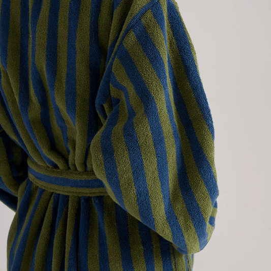 Green and blue striped robe on a neutral background
