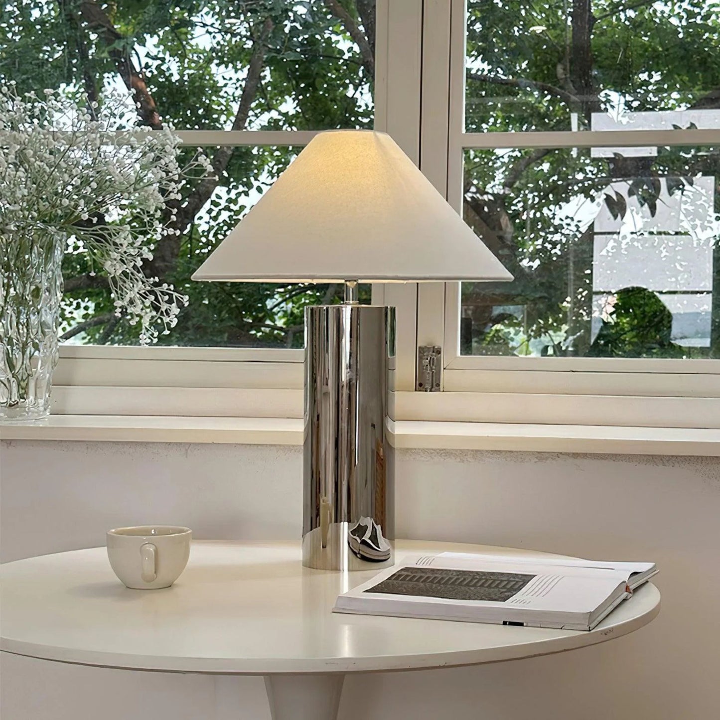 chrome table lamp on a white cube table in a neutral living room