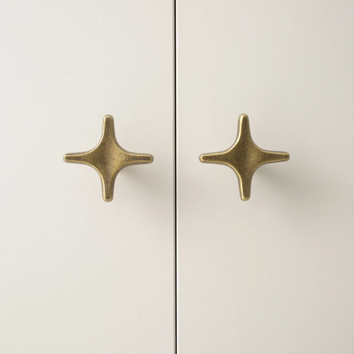 Pair of gold star-shaped earrings on a light background