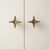 Pair of gold star-shaped earrings on a light background