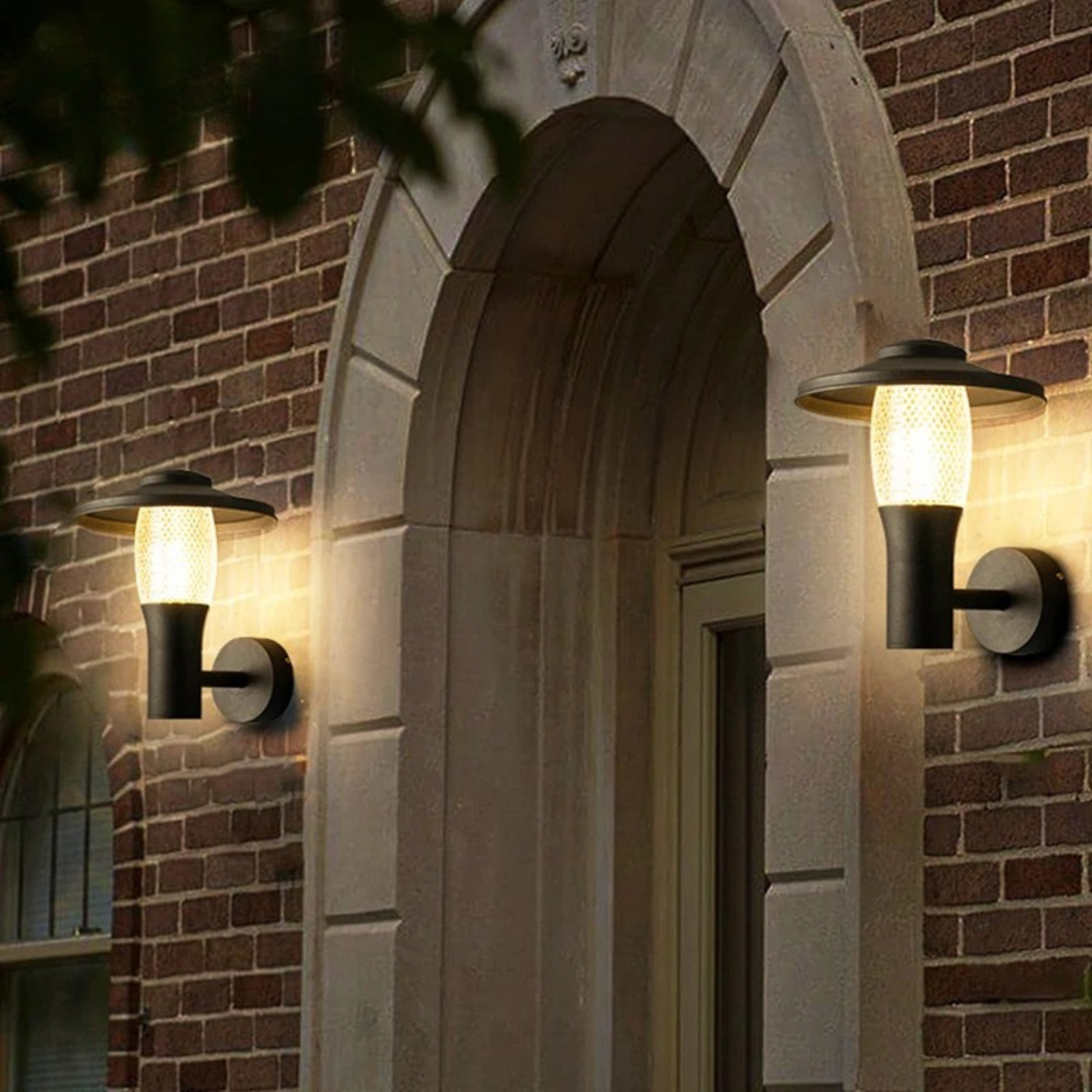 Elegant outdoor wall light mounted beside an arched brick doorway illuminating the entrance