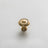 A pair of golden drawer knobs placed on a marble countertop with soft lighting.