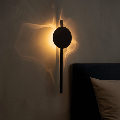 Modern wall lamp with a circular design on a neutral wall.