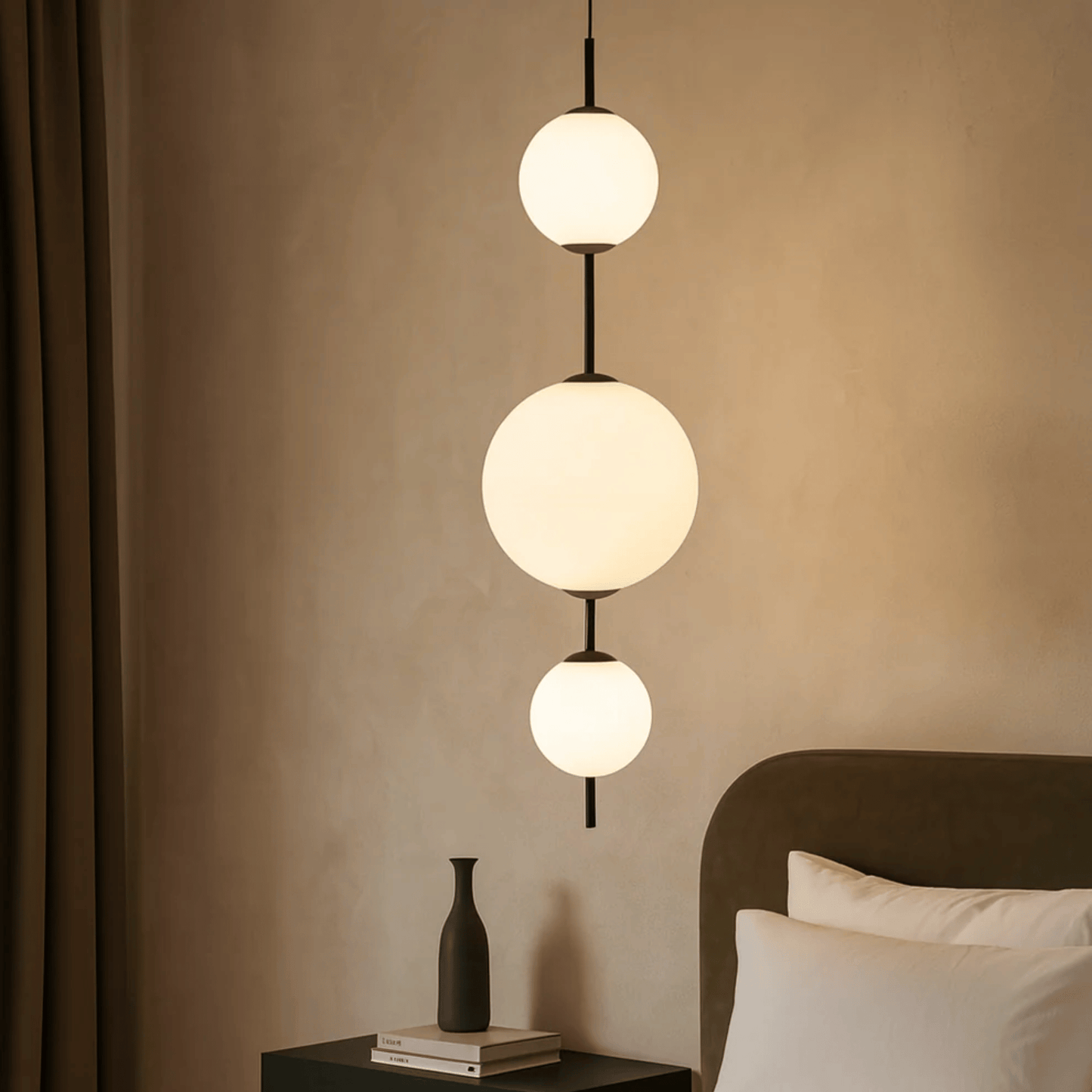 Modern pendant light fixture in a bedroom setting with neutral walls and bedding.