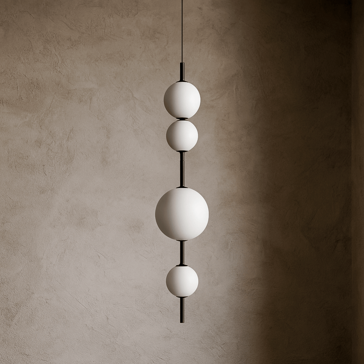 Modern pendant light with three spherical shades against a textured wall.