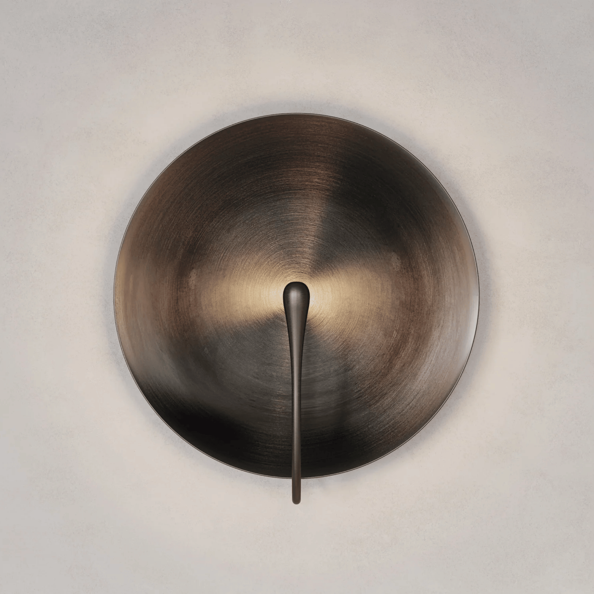 Bronze wall sconce with a minimalist design on a neutral background