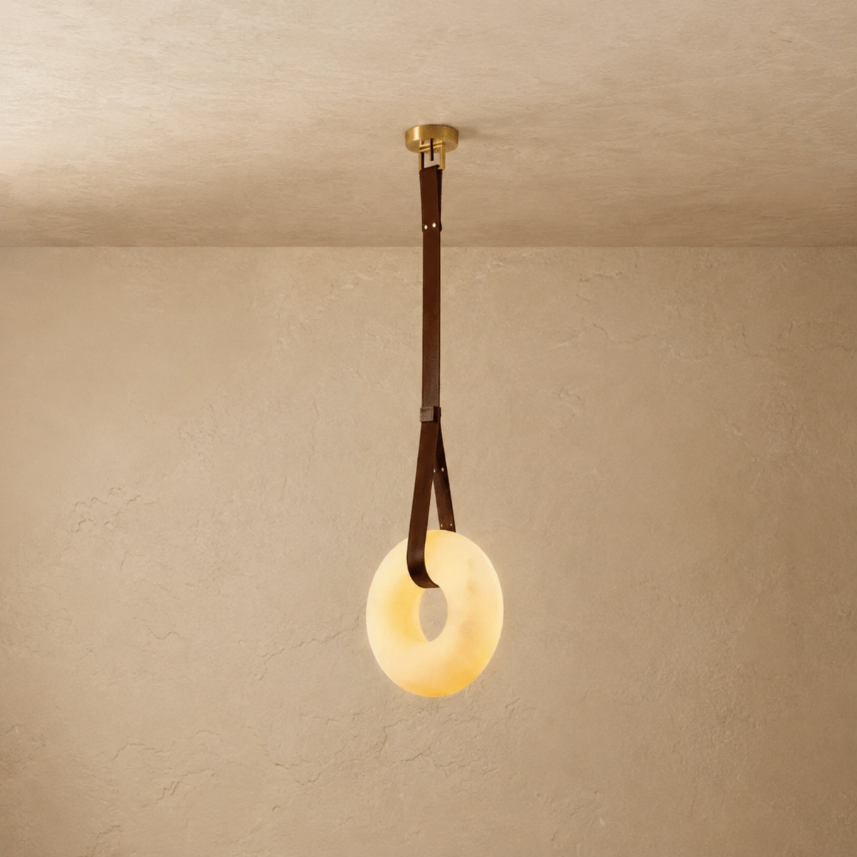 Ceiling light fixture with a round glass shade on a beige wall.
