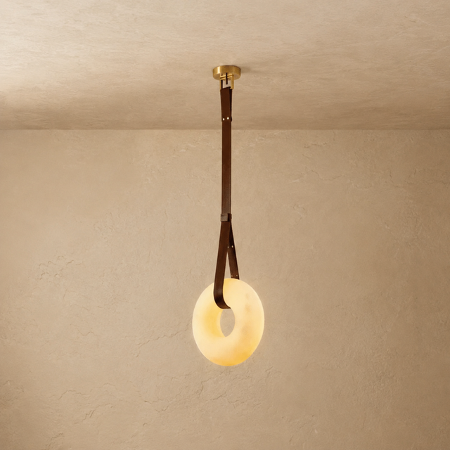 Ceiling light fixture with a round glass shade on a beige wall.