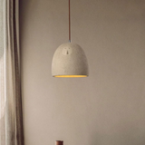Textured pendant light hanging against a beige wall