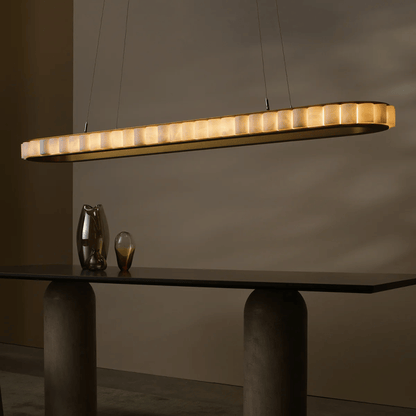 Modern pendant light hanging above a dark table with a neutral background