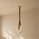Decorative ring hanging from a strap against a beige wall