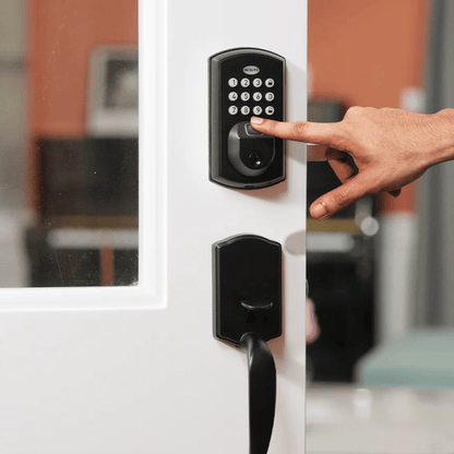 Hand pressing a digital keypad on a door lock with a blurred indoor background