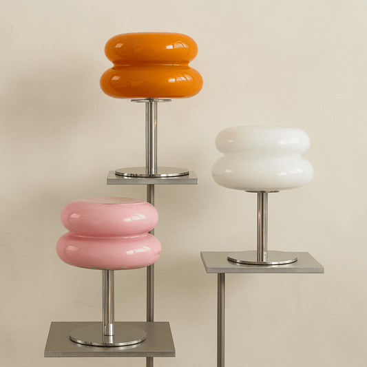 Three modern stools with colorful circular seats on a beige background