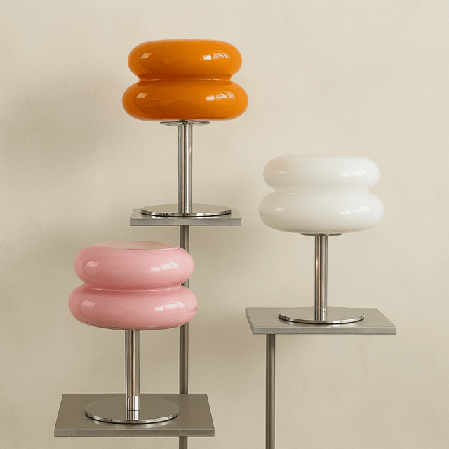 Three modern stools with colorful circular seats on a beige background