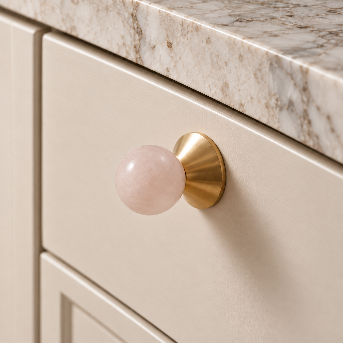 Solvi Brass Ball Cabinet Knobs – Blush Pink – Close-up installed on cream cabinetry