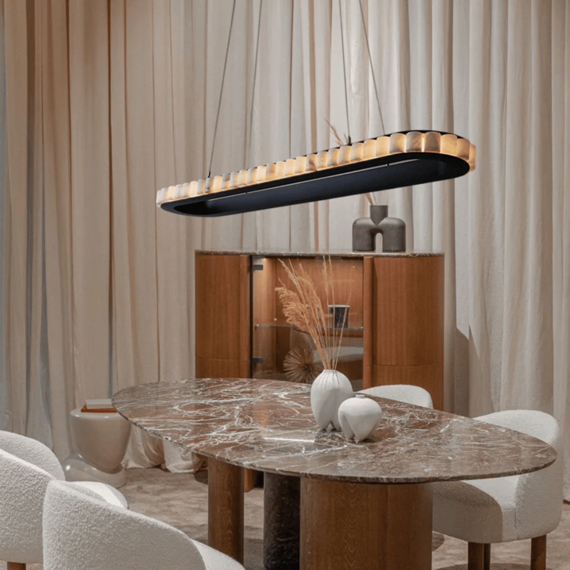 Dining room with a marble table, chairs, and a modern pendant light.