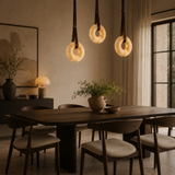 Dining room with a wooden table and chairs, featuring pendant lights and a neutral color palette.