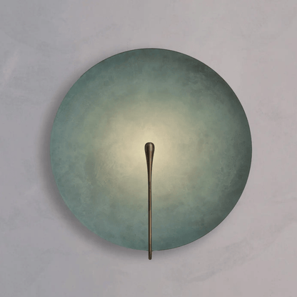 Round wall light fixture with a metallic arm on a gray background