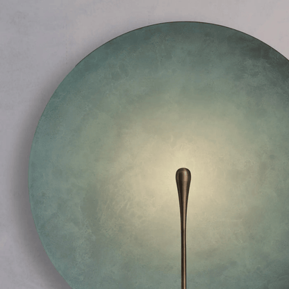 Bronze spoon on a textured green plate with a gradient background
