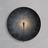 Wall-mounted light fixture with dark circular shade and thin black arm on a gray background