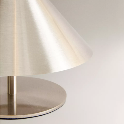 Modern table lamp with a metallic base and shade on a white background