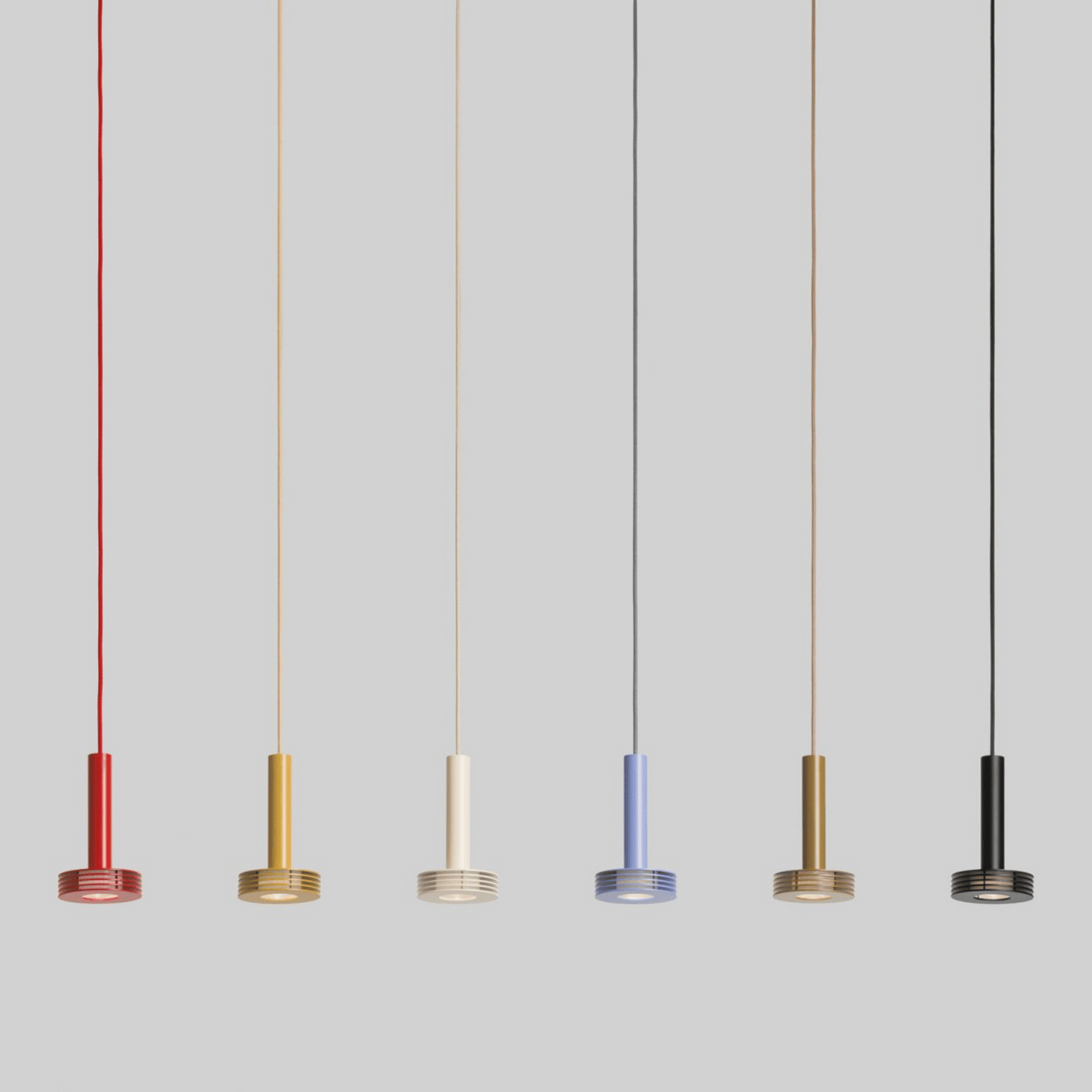 Five pendant lights in different colors hanging against a gray background