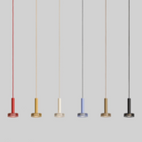 Five pendant lights in different colors hanging against a gray background