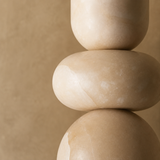 Stack of three beige stones on a matching beige background