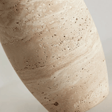 Close-up of a beige stone with a textured surface on a light gray background