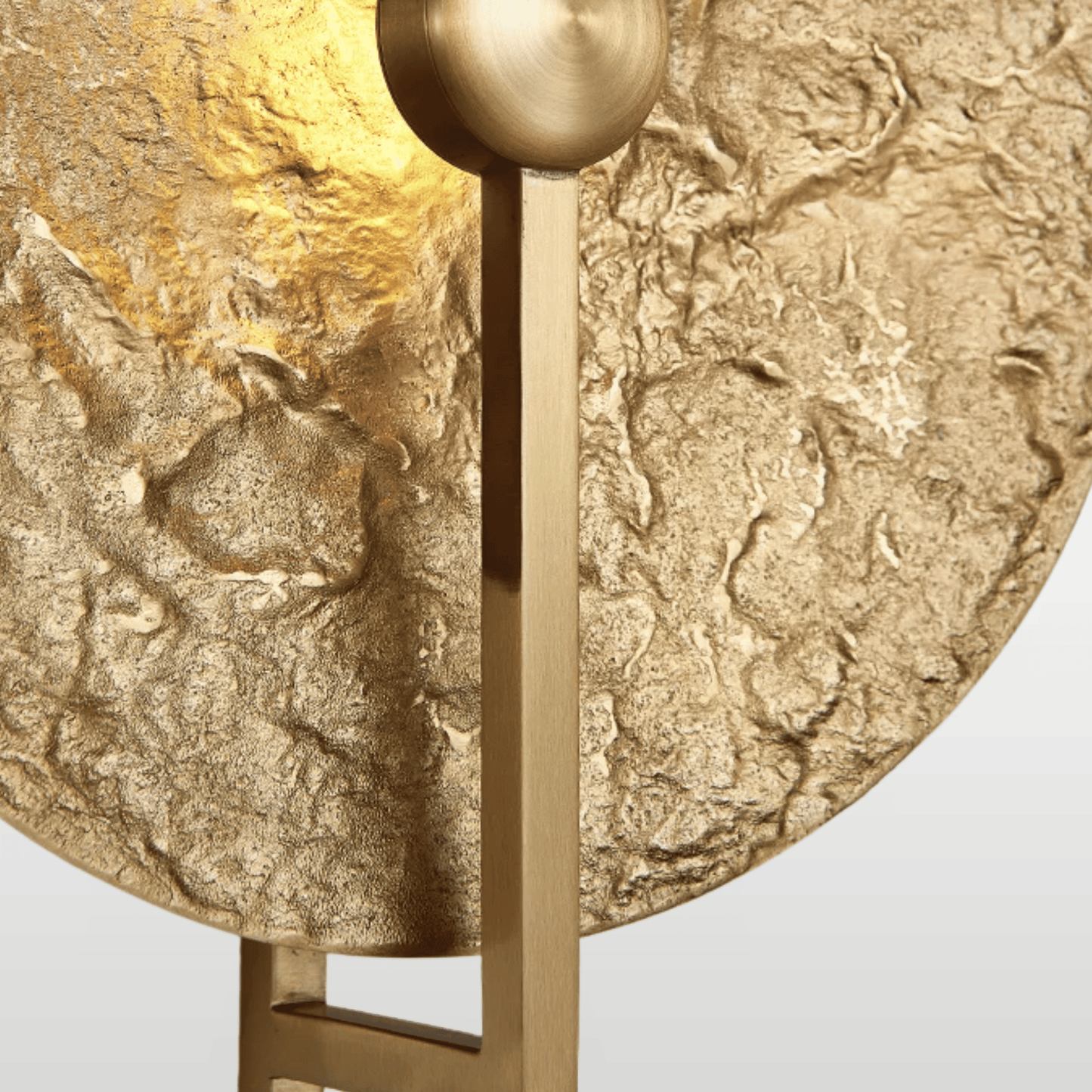 Gold textured round object with a central fixture on a light gray background