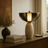 Decorative lamp on a wooden surface with books and a vase in a home setting