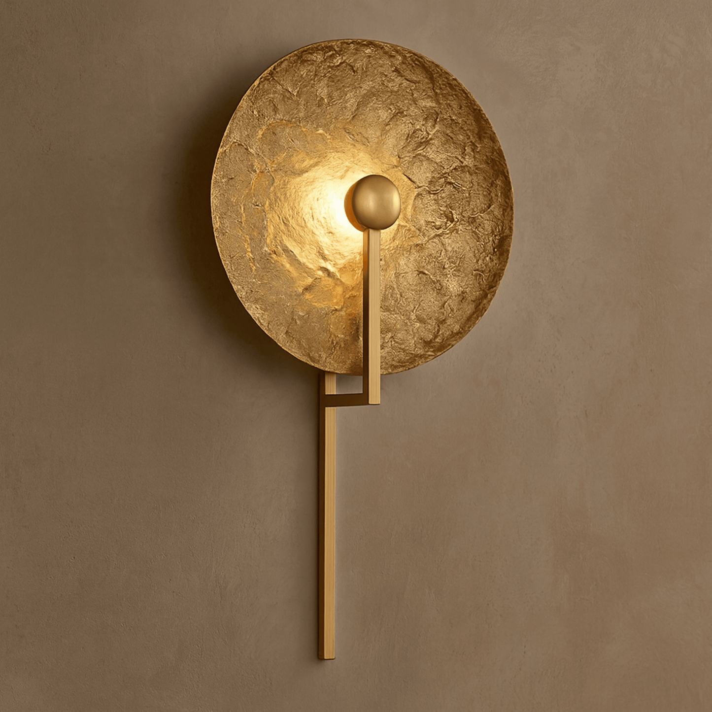 Gold wall sconce on a brown wall