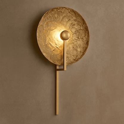 Gold wall sconce on a brown wall