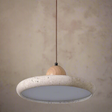 Pendant light with concrete-like shade and wooden fixture on a white background