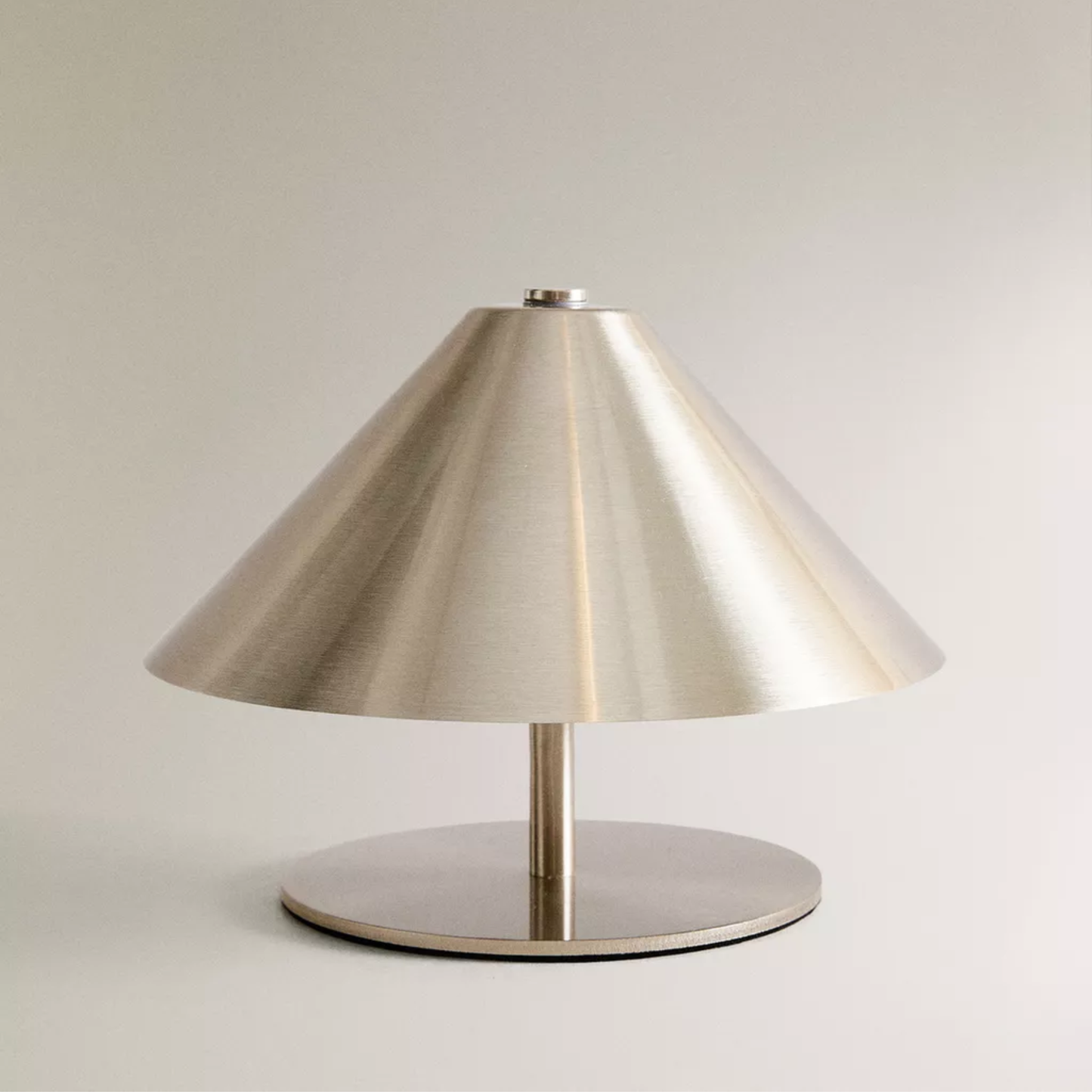 Modern table lamp with a metallic shade on a neutral background