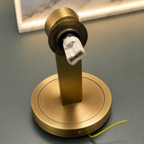 Gold wall-mounted light fixture on a gray surface