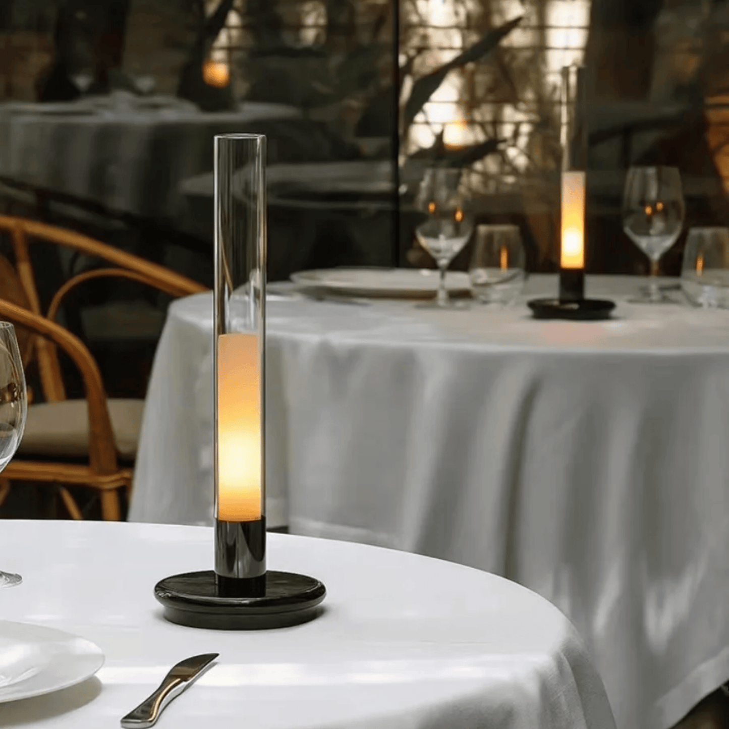Decorative candle on a table with a blurred restaurant setting in the background