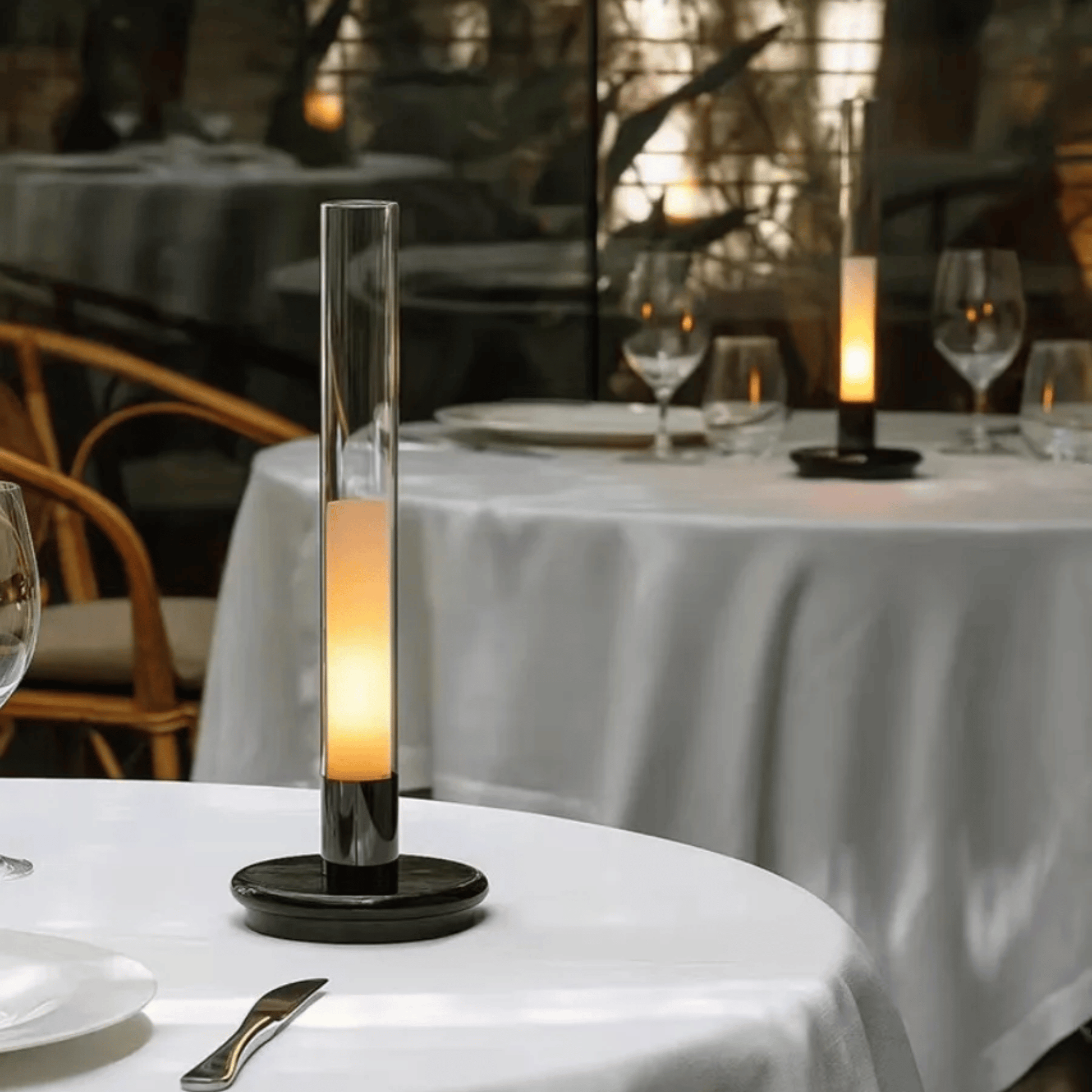 Decorative candle on a table with a blurred restaurant setting in the background