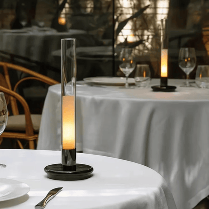 Decorative candle on a table with a blurred restaurant setting in the background