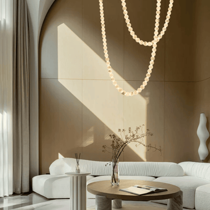 Modern living room with a white sofa, round wooden table, and decorative elements.