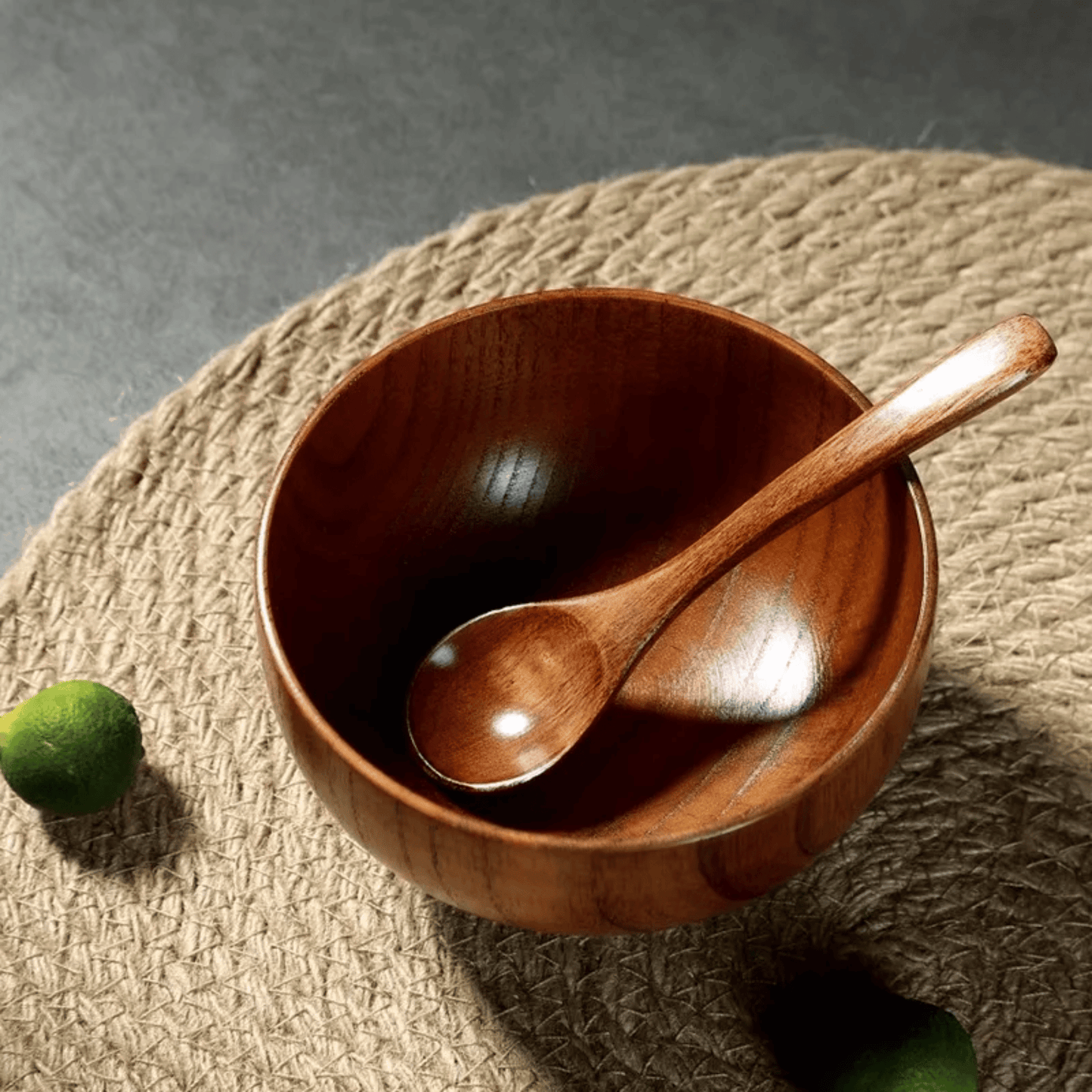 Wooden bowl and spoon on a textured surface