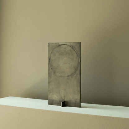 Decorative metal panel with circular design on a beige surface and background