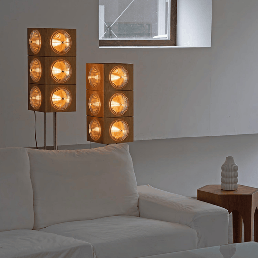 Modern living room with two wooden floor lamps and a white sofa.