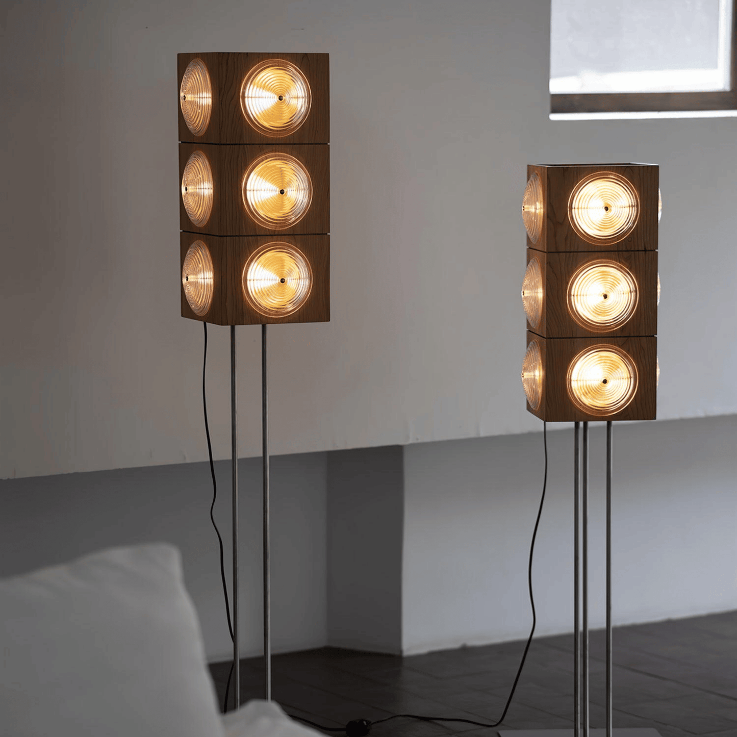 Two modern floor lamps with stacked circular lights on a plain background