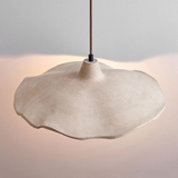 Concrete pendant light with a soft glow on a neutral background