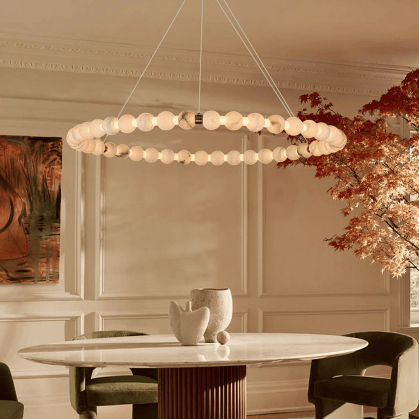 Modern chandelier hanging above a dining table in a stylish room with decor elements.