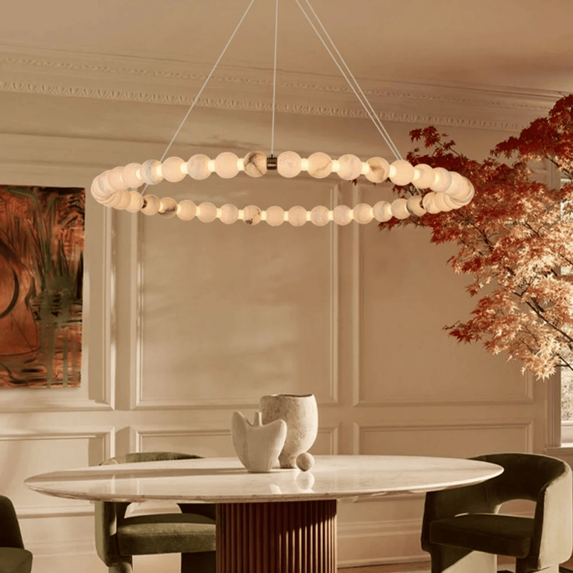 Modern chandelier hanging above a dining table in a stylish room with decor elements.